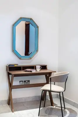 a wooden table with a mirror and a chair at FIRST CLASS 1BR Luxurious DIFC Retreat in Dubai