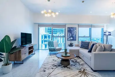 a living room with a couch and a tv at FIRST CLASS 1BR Luxurious DIFC Retreat in Dubai