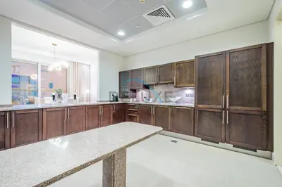 a large kitchen with wooden cabinets and a counter top at Waterfront 2BR Apartment with Assistant Room in Dream Palm Residence, Palm Jumeirah by Deluxe Holiday Homes in Dubai