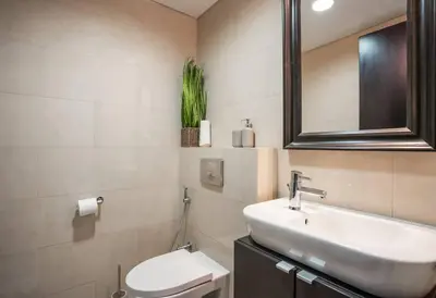 a bathroom with a sink and a toilet and a mirror at Duplex Suite in 5-Star Movenpick Hotel in Dubai