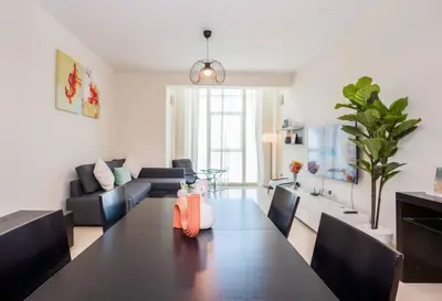a dining room with a table and a living room at Duplex Suite in 5-Star Movenpick Hotel in Dubai