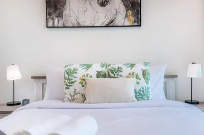 a bedroom with a white bed with two lamps at RH - Stunning Canal View 01 BR with Top amenities, newly furnished in Dubai