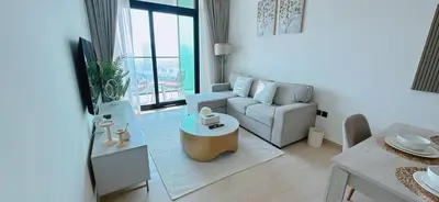 a living room with a couch and a table at Bright & Cozy 1br Jvc Balcony Free Parking in Dubai