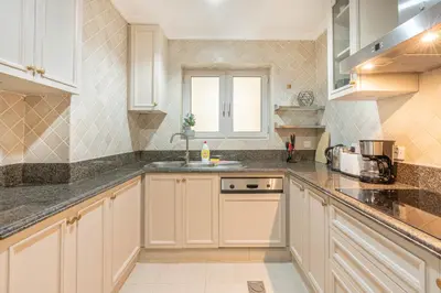 a kitchen with white cabinets and a sink at Souk Al Bahar Home with direct Dubai Mall Access in Dubai