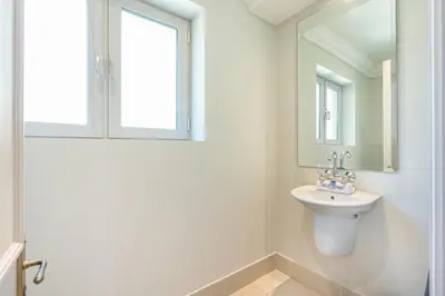 a white bathroom with a sink and a window at Souk Al Bahar Home with direct Dubai Mall Access in Dubai