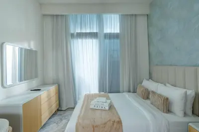 a bedroom with a large white bed and a mirror at Nasma Luxury Stays - Dreamy Getaway Unwind in a Modern Dubai Studio in Dubai