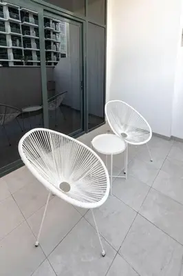 two white chairs and a table in a room at Nasma Luxury Stays - Dreamy Getaway Unwind in a Modern Dubai Studio in Dubai