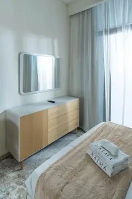 a bedroom with a dresser with a television on it at Nasma Luxury Stays - Dreamy Getaway Unwind in a Modern Dubai Studio in Dubai