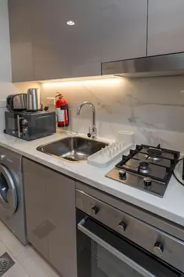 a kitchen counter with a sink and a stove at Nasma Luxury Stays - Dreamy Getaway Unwind in a Modern Dubai Studio in Dubai