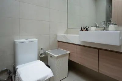 a white bathroom with a sink and a toilet at Nasma Luxury Stays - Cozy Urban Studio at Azizi Riviera 43 in Meydan in Dubai