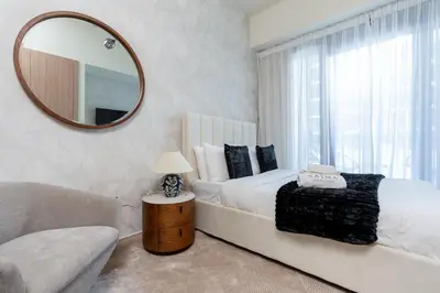 a bedroom with a large bed and a mirror at Nasma Luxury Stays - Cozy Urban Studio at Azizi Riviera 43 in Meydan in Dubai