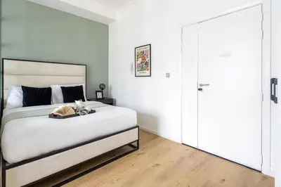 a bedroom with a large white bed with a wooden floor at Frank Porter - DEC Tower 3 in Dubai