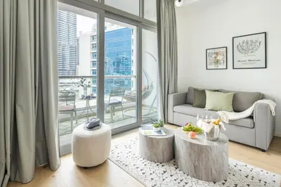 a living room with a couch and a large window at Frank Porter - DEC Tower 3 in Dubai