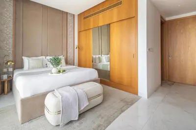 a bedroom with a large white bed and a room with a bed sqor at Frank Porter - The One JBR in Dubai