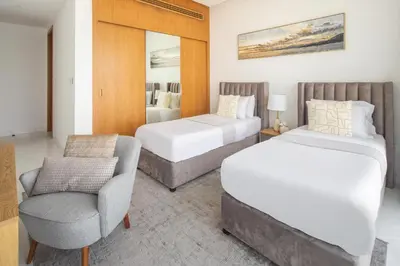 a hotel room with two beds and a chair at Frank Porter - The One JBR in Dubai