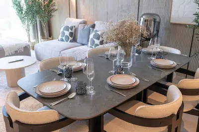 a dining room table with plates and wine glasses at Downtown Views Open Burj View 34th Floor 2BD in Dubai