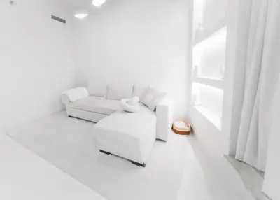 a white living room with a white couch and a chair at Luxuriöses Apartment mit Burj Khalifa View in Dubai