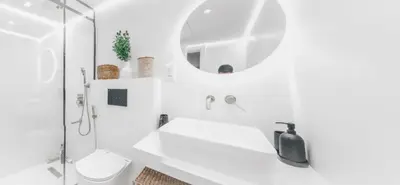a white bathroom with a sink and a mirror at Luxuriöses Apartment mit Burj Khalifa View in Dubai
