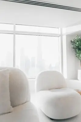a white chair in a room with a window at Luxuriöses Apartment mit Burj Khalifa View in Dubai