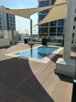 a swimming pool on the roof of a building with an umbrella at Dubai Galaxy in Azizi Riviera Luxury Studio in Dubai