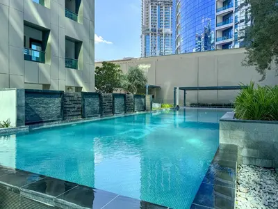 a large swimming pool in the middle of a building at 3BR Apartment in Business Bay with Pool & Canal Walk in Dubai