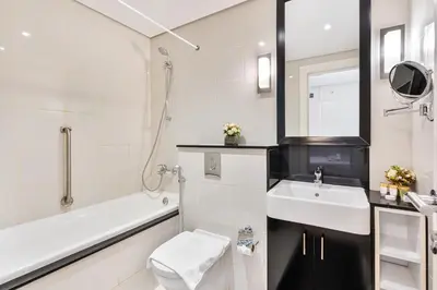 a bathroom with a sink and a toilet and a bath tub at 3BR Apartment in Business Bay with Pool & Canal Walk in Dubai