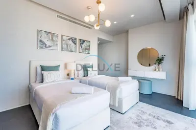 two beds in a bedroom with a mirror at Luxurious 2BR at DAMAC Heights, Dubai Marina by Deluxe Holiday Homes in Dubai