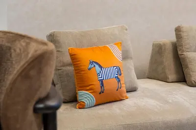 an orange pillow with a zebra on it sitting on a chair at Pool side view at Dubai Creek Harbour by DuStay in Dubai