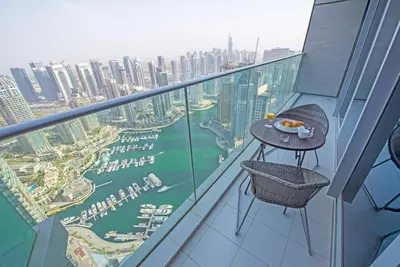 a table on a balcony with a view of a city at FIRST CLASS 1BR Amazing Marina Views in Dubai