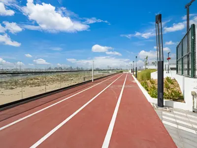 an empty red road next to the beach at Dar Mama - Cozy modern apartment in Golf Vita, Dubai in Dubai