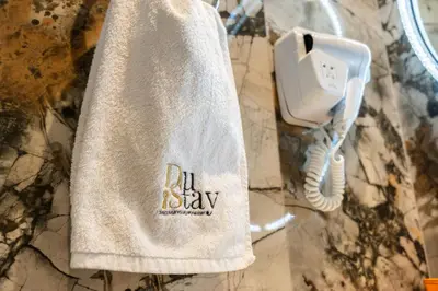 a white towel hanging on a wall with a phone at Spacious Apartment - Dubai Creek Harbour by DuStay in Dubai