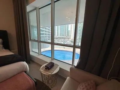 a hotel room with a view of a swimming pool from a window at 2 Bedrooms Apartment with Marina Views in Dubai