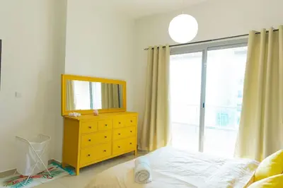 a bedroom with a yellow dresser and a mirror at Himalaya Holiday Homes 1 BHK Apartment in Dubai