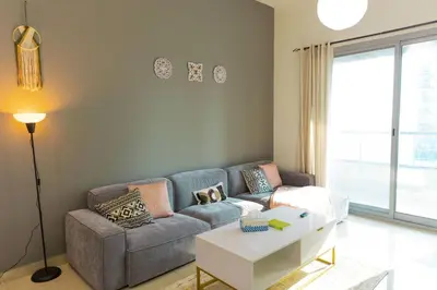 a living room with a couch and a table at Himalaya Holiday Homes 1 BHK Apartment in Dubai