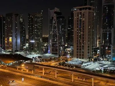a city skyline at night with cars on a freeway at Himalaya Holiday Homes 1BHK - Dubai Marina in Dubai