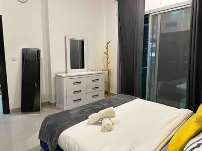 a bedroom with a bed with a television and a dresser at Himalaya Holiday Homes 1BHK - Dubai Marina in Dubai