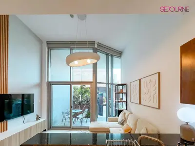 a living room with a couch and a glass table at Modern studio in villa Pera tower JVC in Dubai