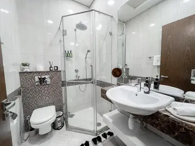 a bathroom with a shower and a toilet and a sink at Modern studio in villa Pera tower JVC in Dubai