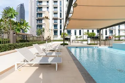 a row of lounge chairs next to a swimming pool at Iconic 1BR l Boulevard View l Walk to Dubai Mall in Dubai