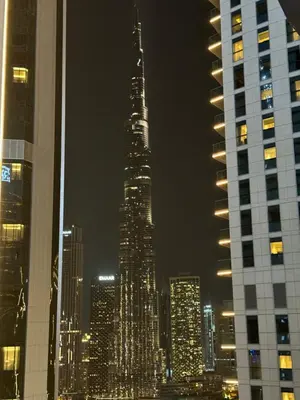 a tall building in a city at night at Royal Apartments Dubai Mall in Dubai