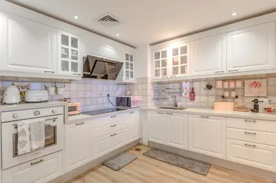 a kitchen with white cabinets and white appliances at Elegant 2 Bedroom Apartment in Dubai Marina- Just 1 Min walk from JBR Beach in Dubai