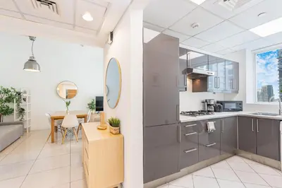 a kitchen and living room with a table and chairs at Beautiful Home at the Heart of Marina in Dubai