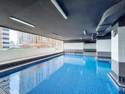a large swimming pool in a building with a window at Beautiful Home at the Heart of Marina in Dubai