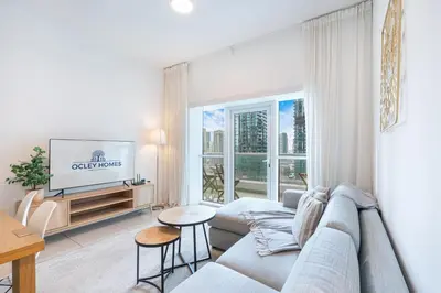 a living room with a couch and a tv at Beautiful Home at the Heart of Marina in Dubai