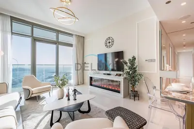a living room with a fireplace and a tv at Classy 3BR with Assistant Room at Sunrise Bay Tower 1 Emaar Beachfront, Dubai Marina by Deluxe Holiday Homes in Dubai