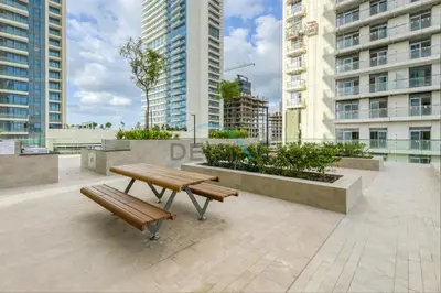 a picnic table and benches in a city with tall buildings at Classy 3BR with Assistant Room at Sunrise Bay Tower 1 Emaar Beachfront, Dubai Marina by Deluxe Holiday Homes in Dubai
