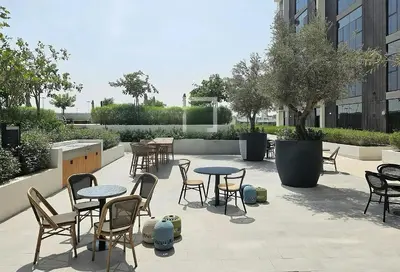 a patio with tables and chairs in a building at Studio Hotel Apartment Brand New Azizi Riv 14 in Dubai