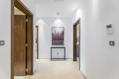 a hallway with two doors and a painting on the wall at Oceana Baltic Palm West Beach Views 3 bd Sleeps 7 in Dubai