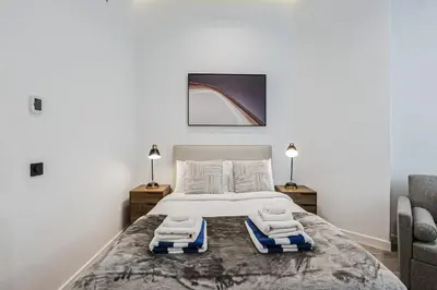 a bedroom with a large bed with towels on it at Luxury at Beachside Al Sultana Jumeirah Shoreline - DVH Holiday Homes in Dubai