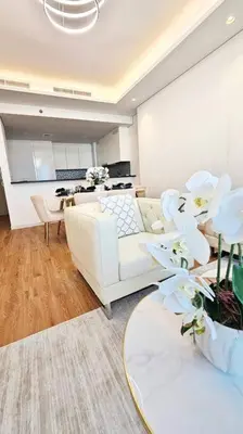 a living room with a white couch and a table at Luxury 2BR Midtown Apartment in Dubai